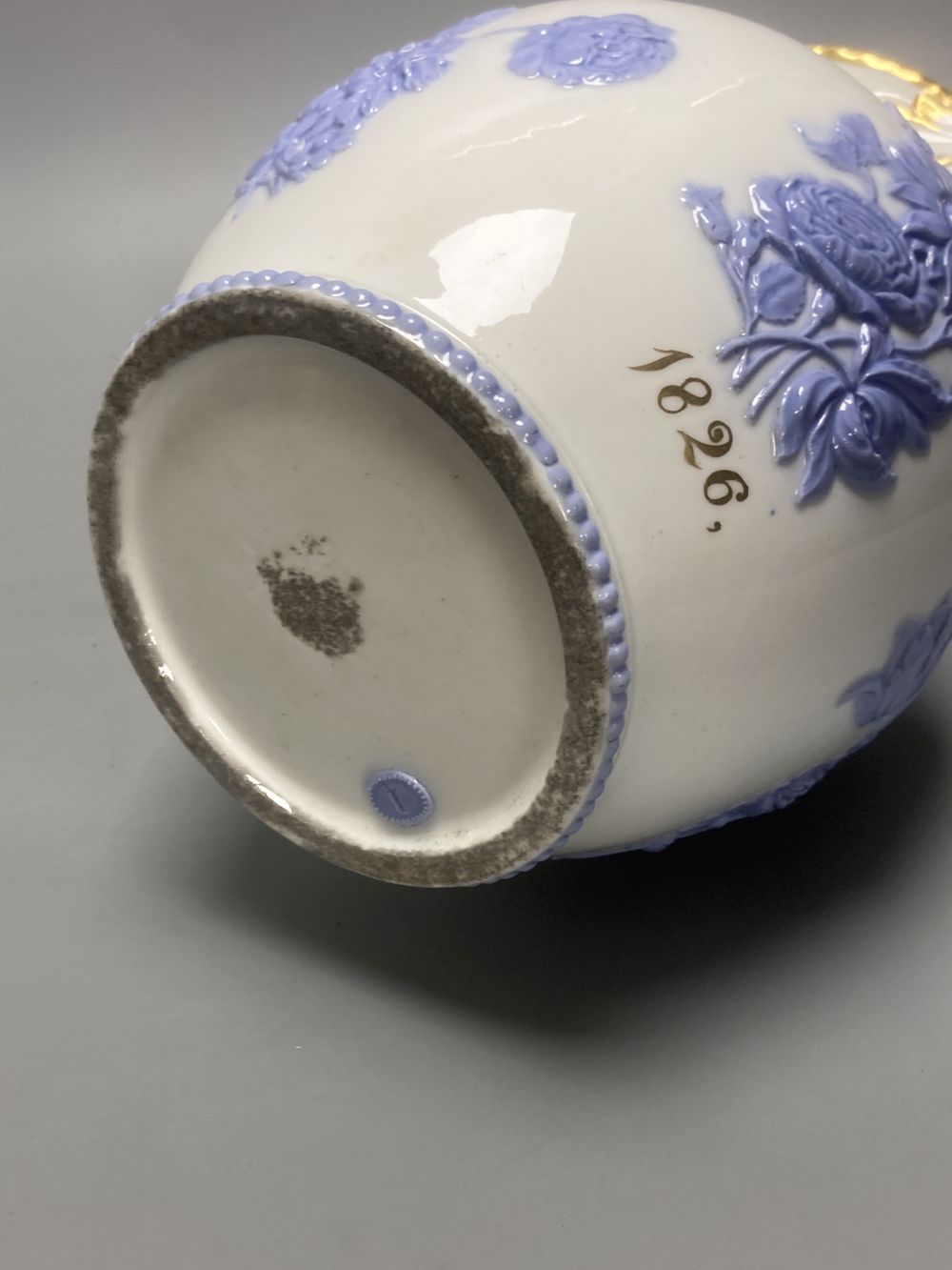 Four early 19th century Staffordshire jugs, each with lilac coloured floral applied panels, one dated 1826, tallest 22cm
